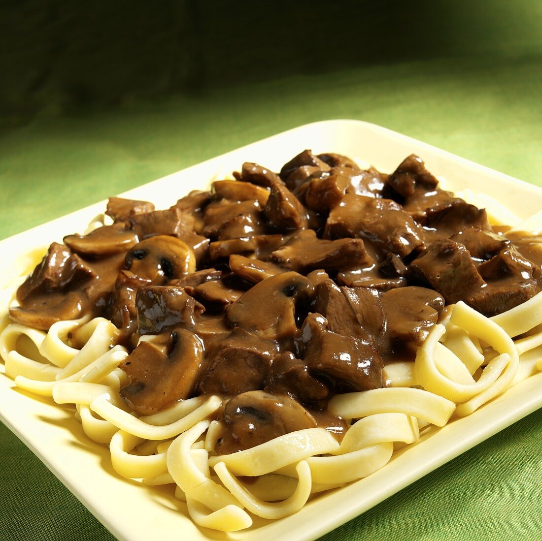 Beef ragout with mushrooms on ribbon pasta