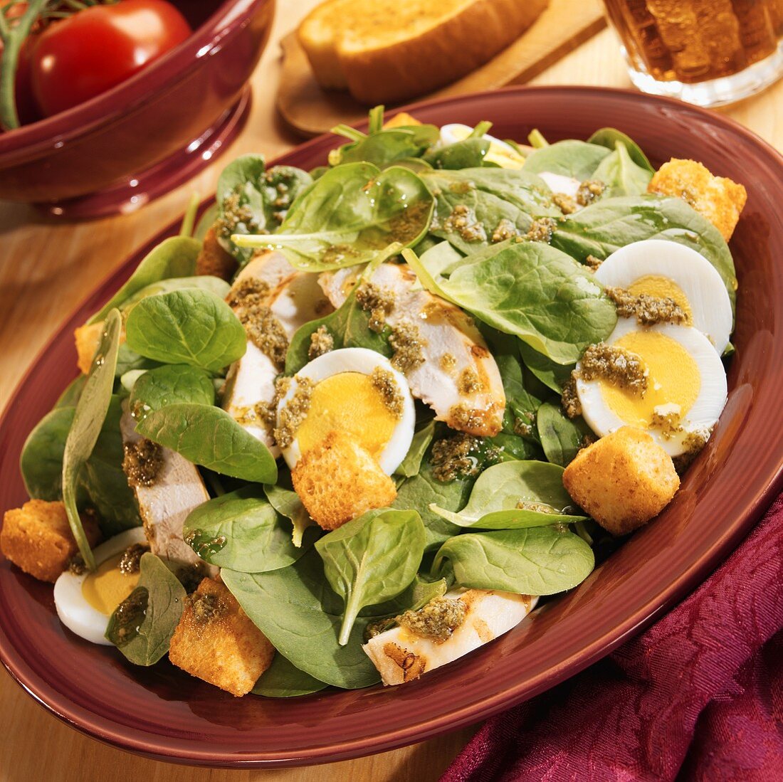 Spinach salad with chicken, egg, croutons and pesto