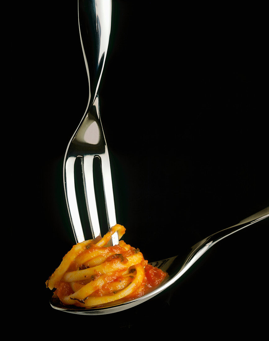 Spaghetti mit Tomatensauce um Gabel wickeln