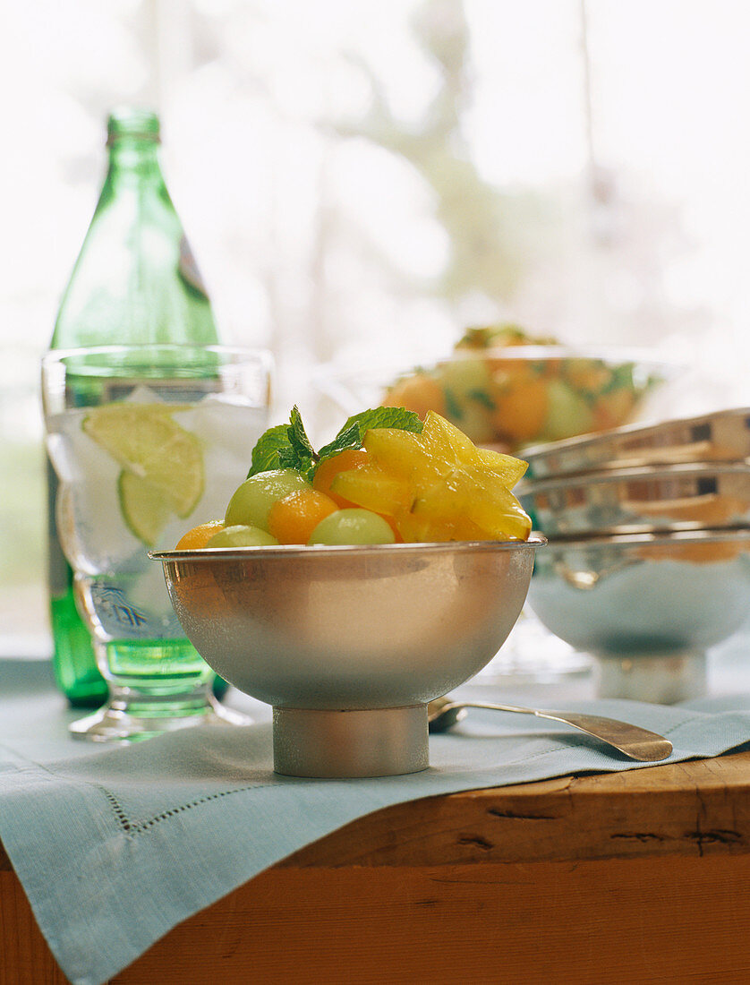 Melon and carambola salad with mint; mineral water