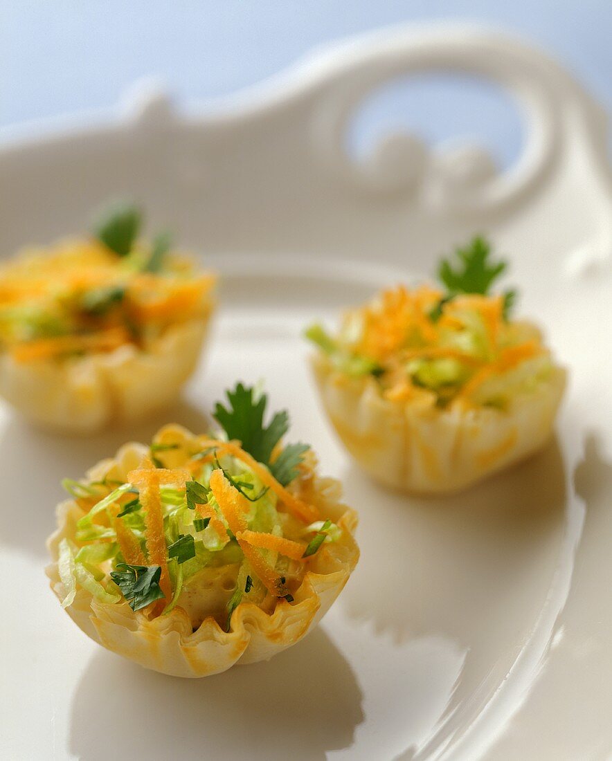 Puff Pastry Hors d'Oeuvres Filled with Cheese and Salad on a White Platter with Handles