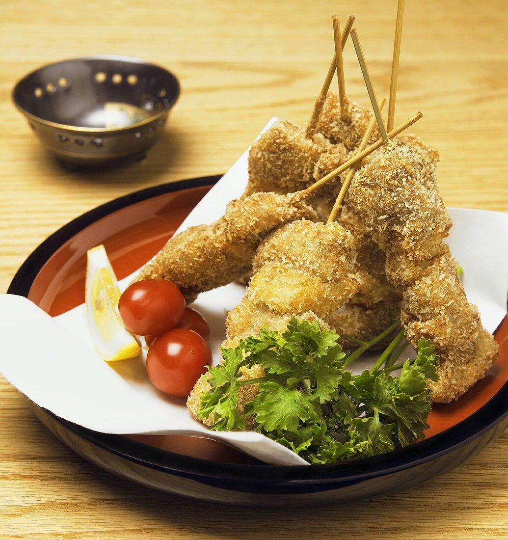 Panierter Fisch auf Spiesschen, Petersilie und Kirschtomaten