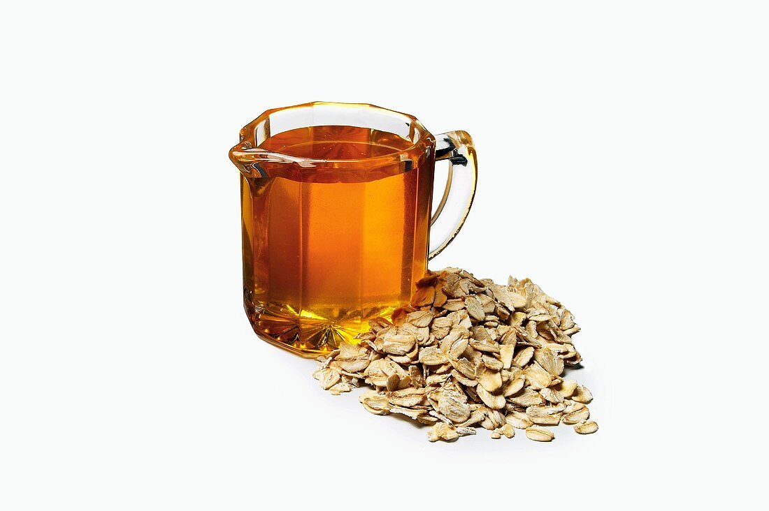 A Pitcher of Honey Next to a Pile of Oats