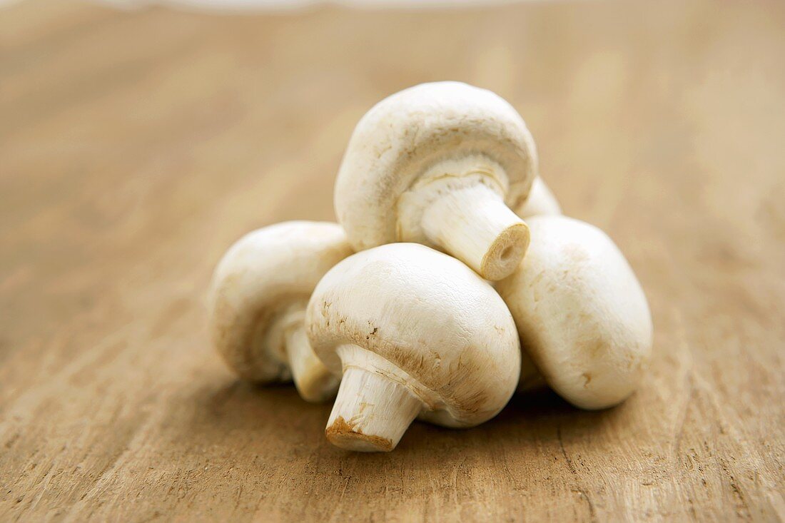 Einige Champignons auf Holzuntergrund