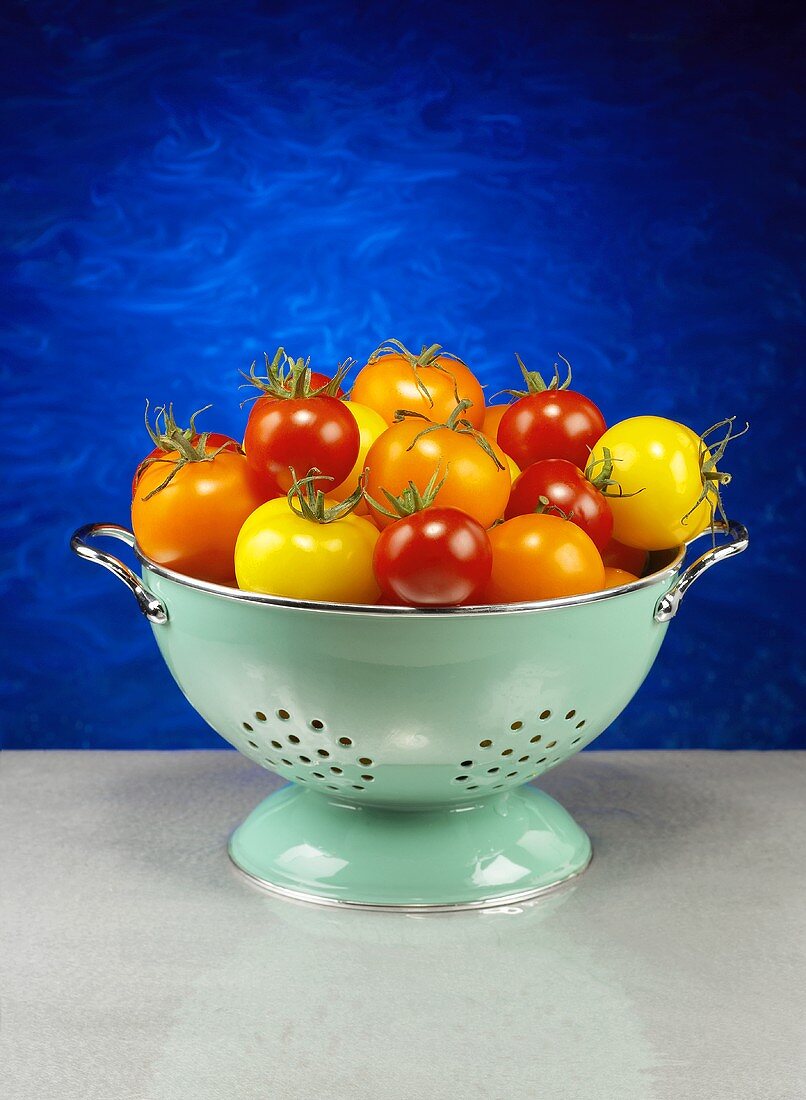Assorted Tomatoes in a Green Colander
