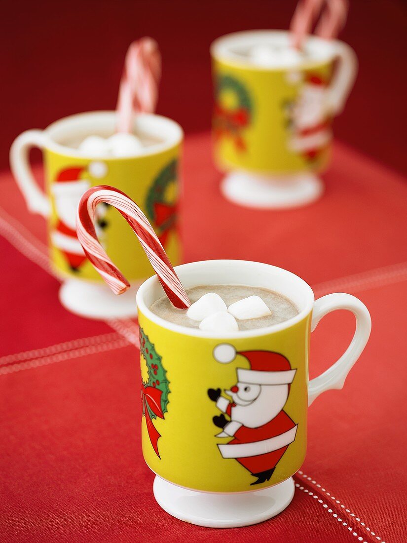 Hot Chocolate in Christmas Mugs with Candy Canes and Marshmallows