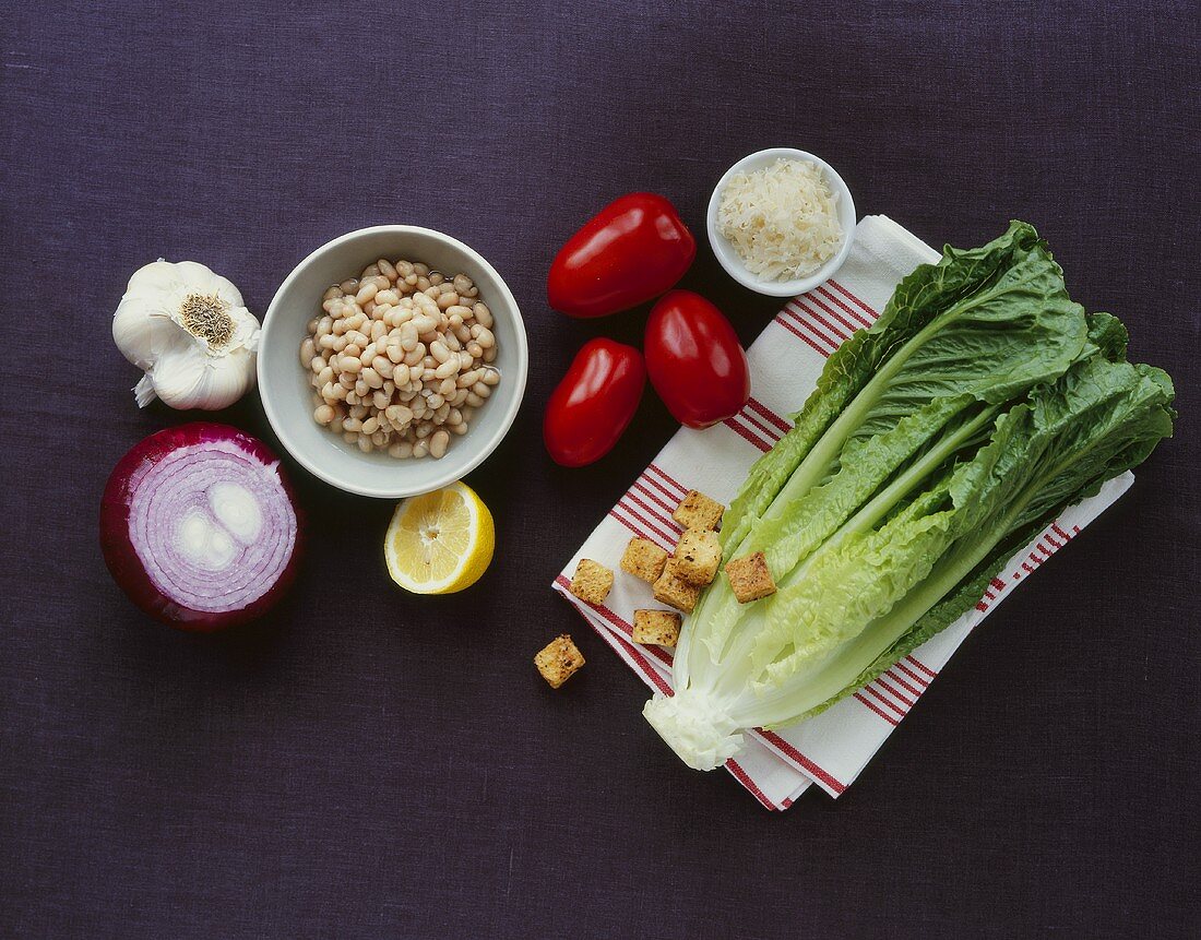 Ingredients for Caesar salad with white beans, onions, croutons