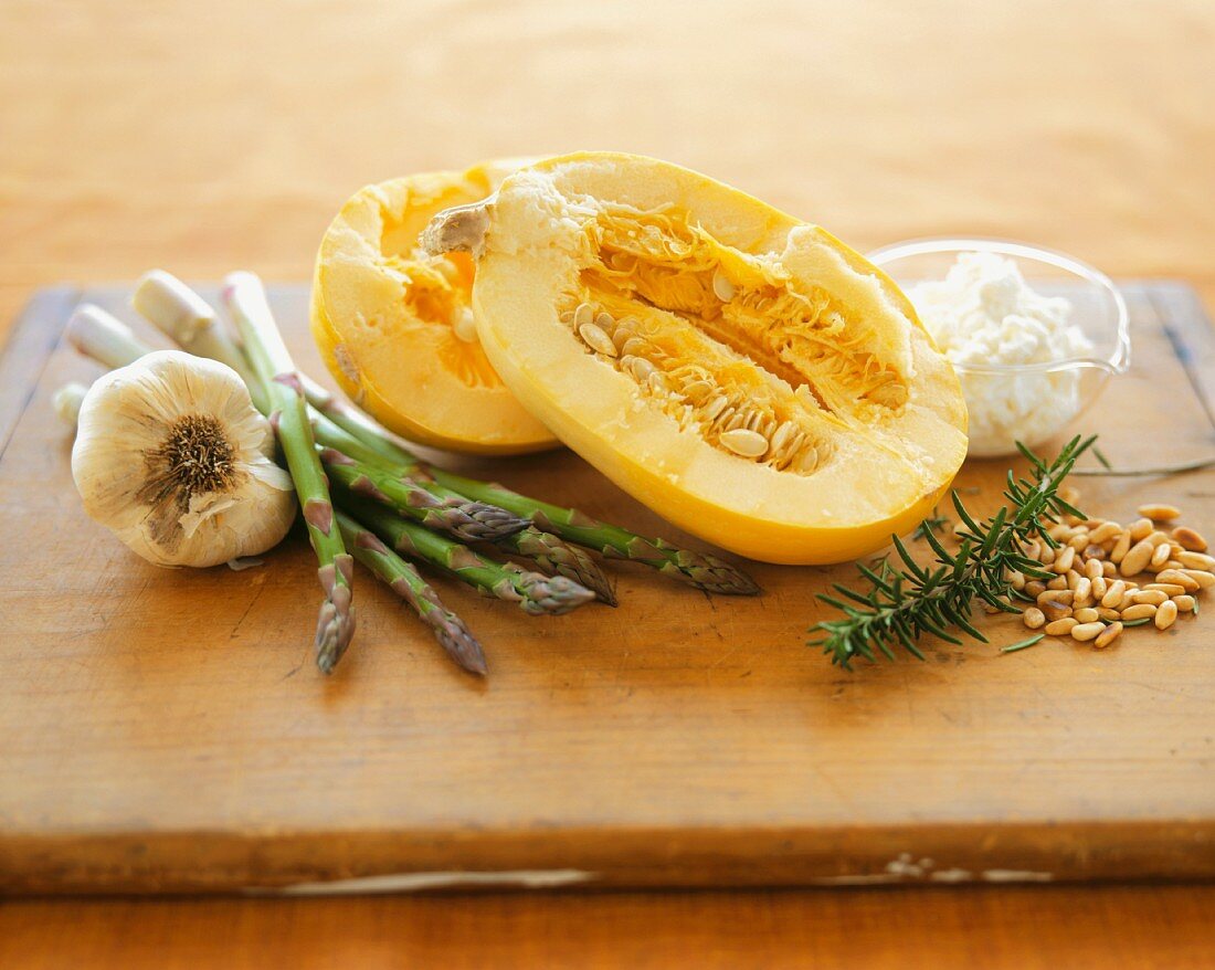 Still Life with Spaghetti Squash, Garlic, Asparagus, Rosemary and Pine Nuts on a Wooden Board