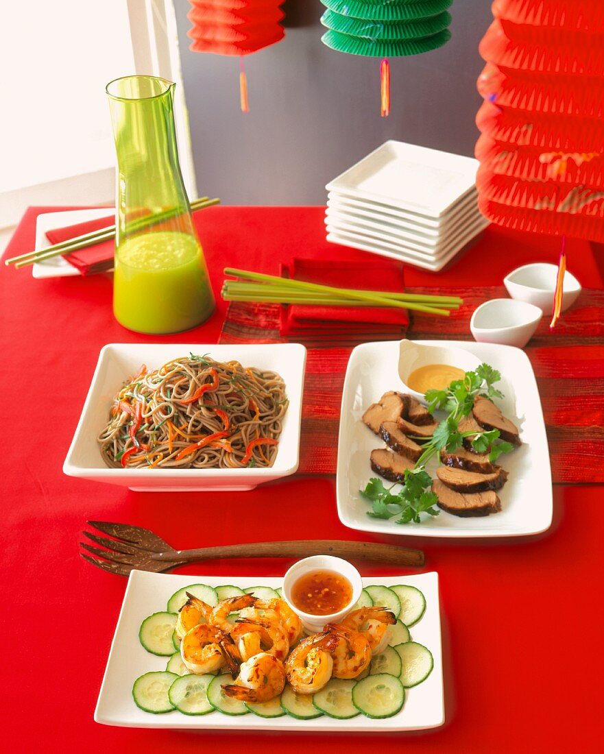 Asian Dishes on a Festive Table (Soba Noodles, Shrimp and Sliced Pork Loin with Coriander)