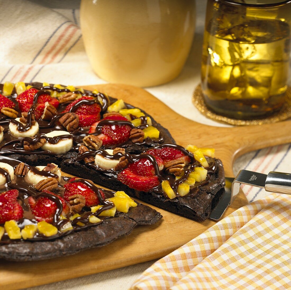 A Brownie Pizza with Fresh Fruit on a Wooden Paddle