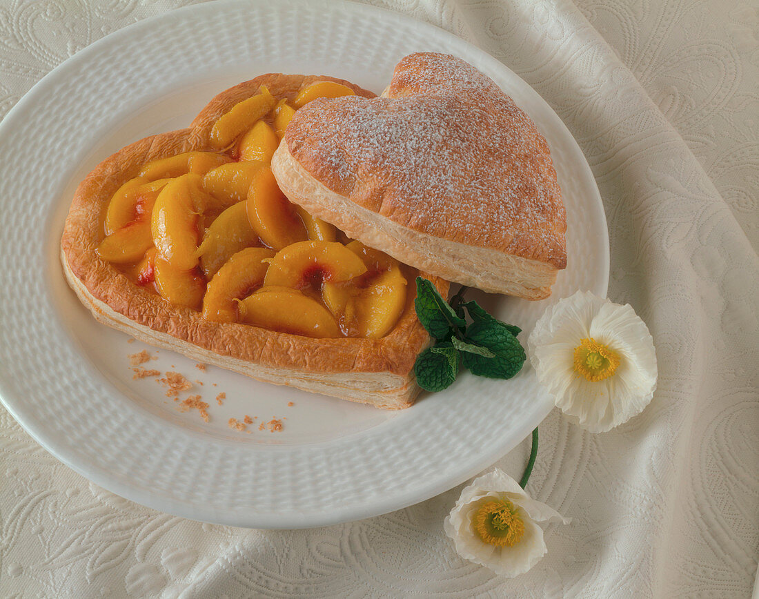 A Heart Shaped Puff Pastry Tart with Peaches and Powdered Sugar