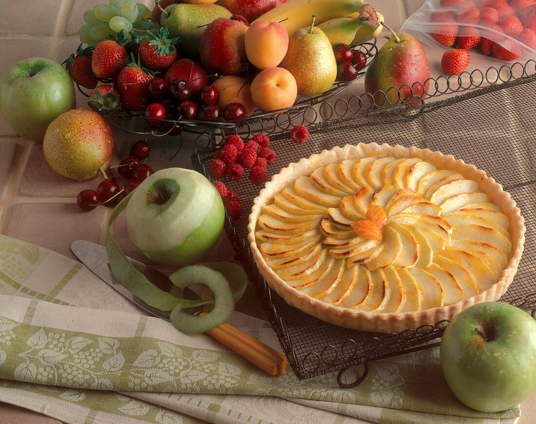 A Whole Apple Tart Surrounded by Fresh Fruit