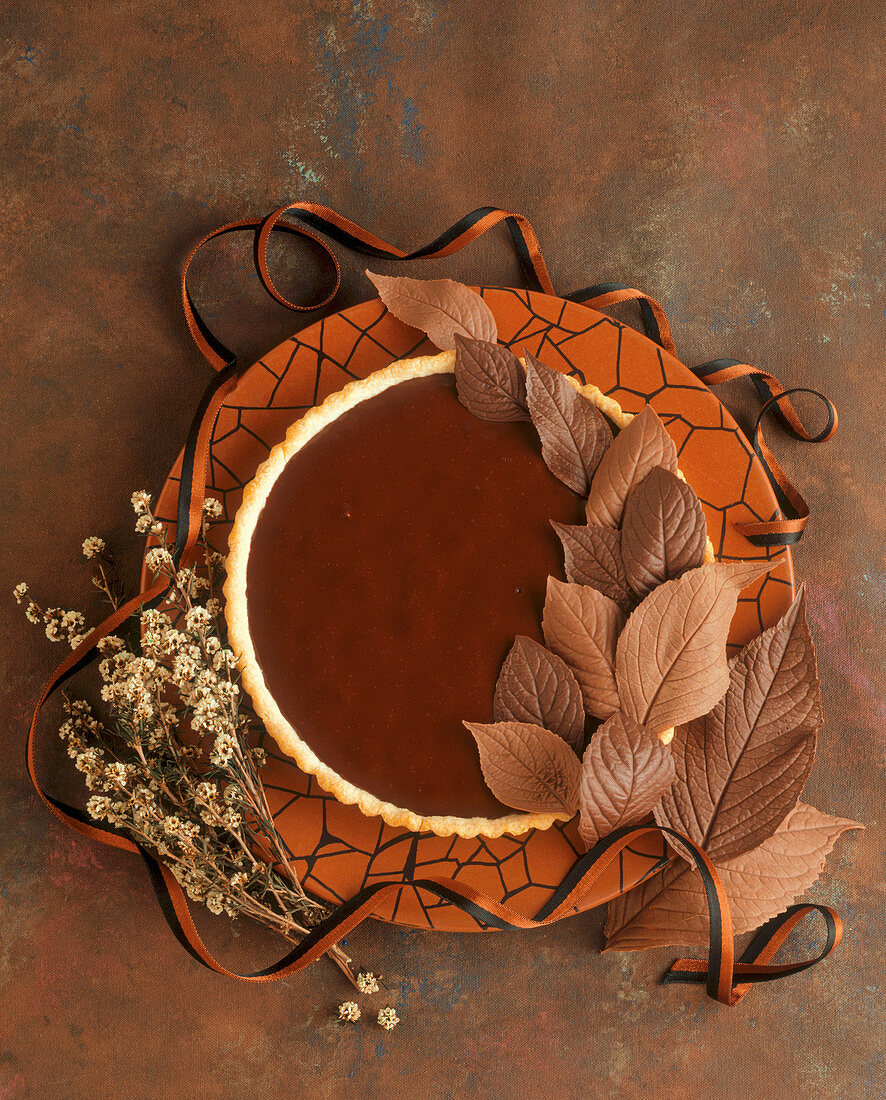 A chocolate caramel tart with chocolate leaves