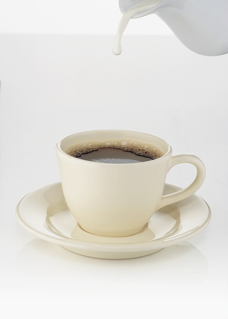 A Drop of Milk Falling from a Pitcher into a Cup of Coffee