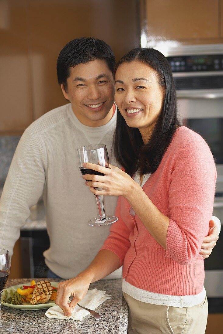 Junges Paar trinkt Rotwein zum Essen in der Küche