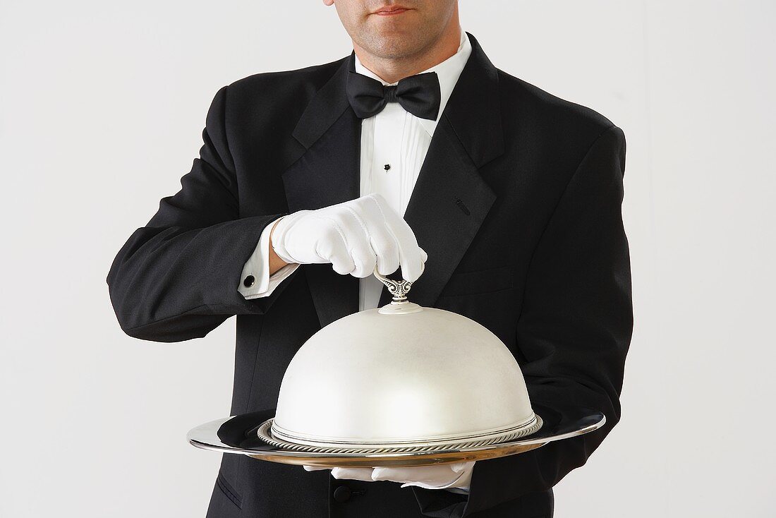 Butler holding a domed silver serving tray