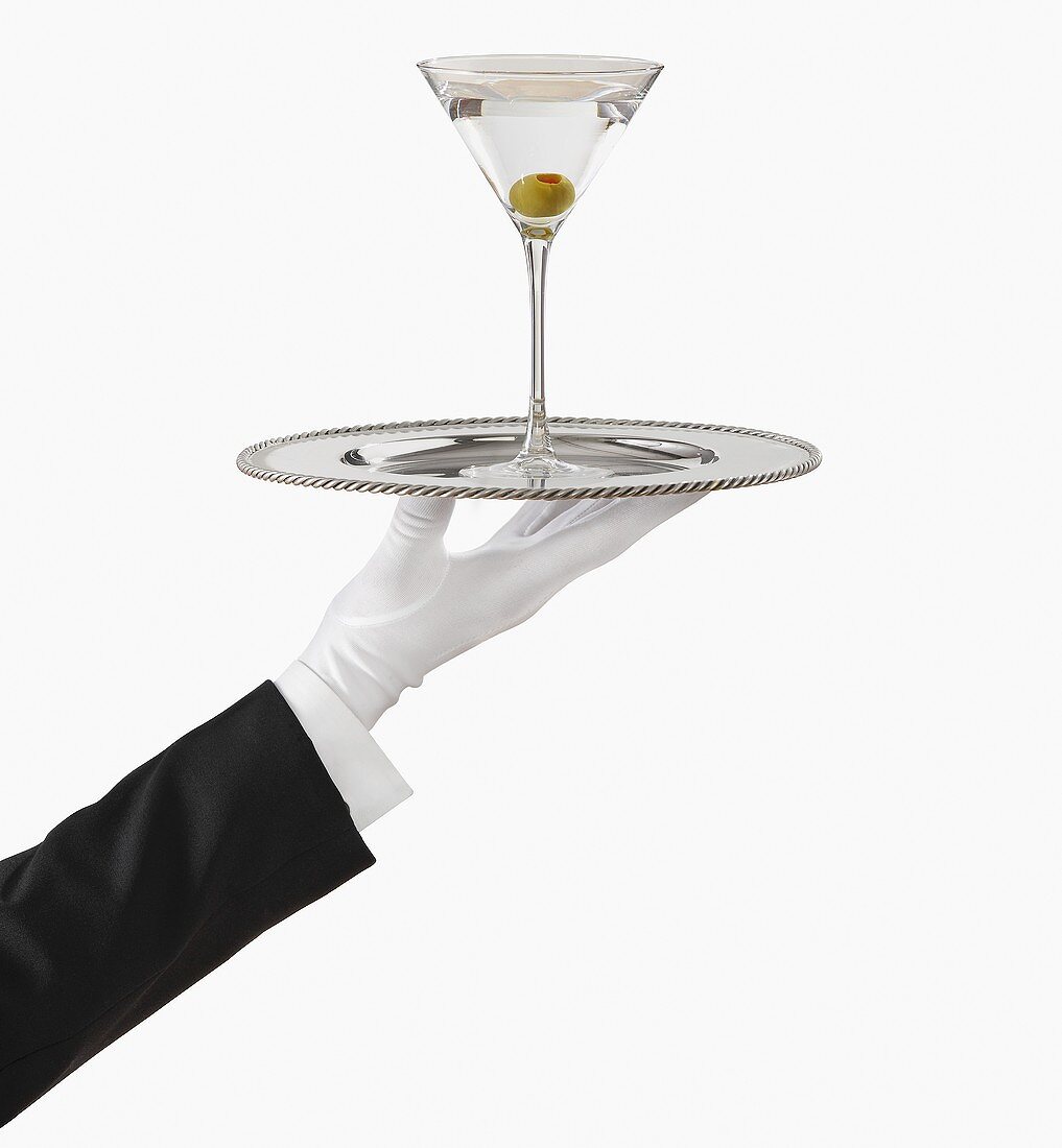 Hand mit weißem Handschuh hält Tablett mit Martini