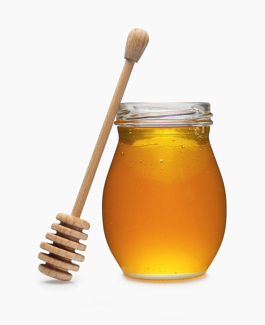 Honig im Glas mit angelehntem Honigkamm