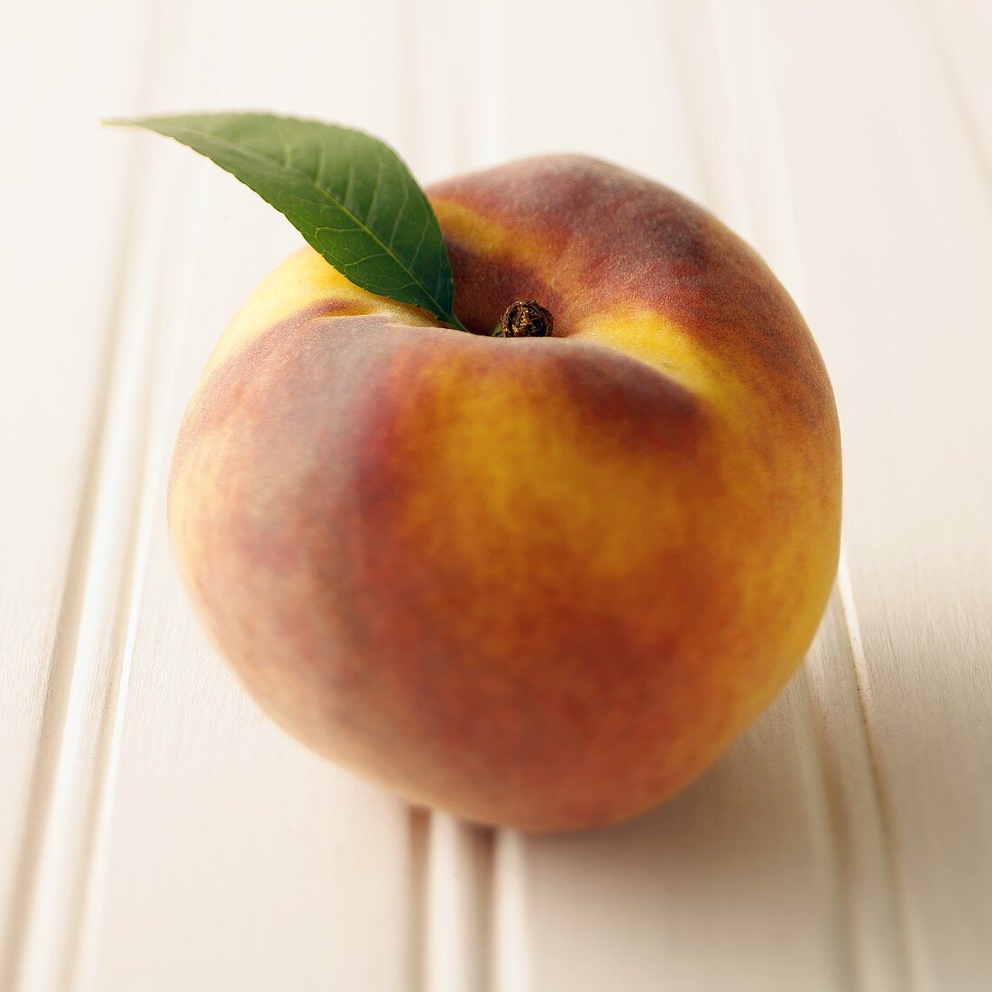 A Whole Peach with a Single Leaf