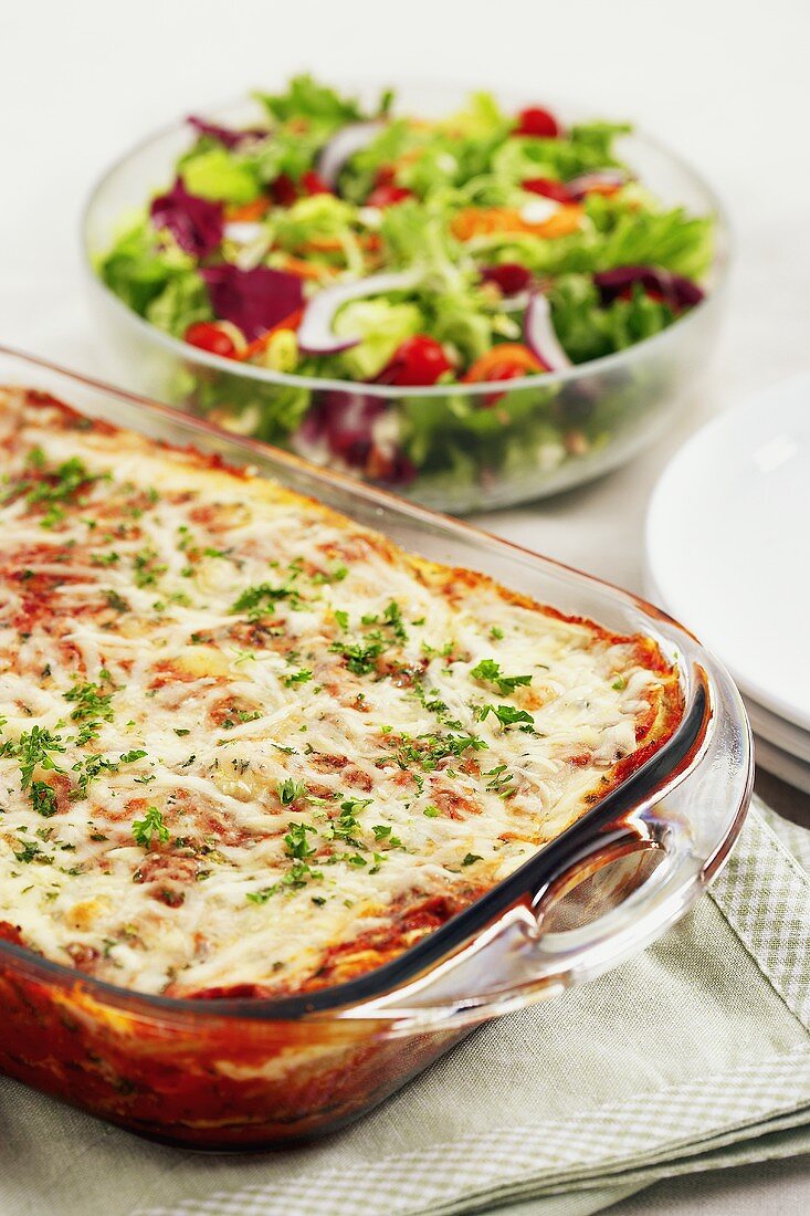 Lasagna in a Glass Baking Dish and Salad in a Serving Bowl