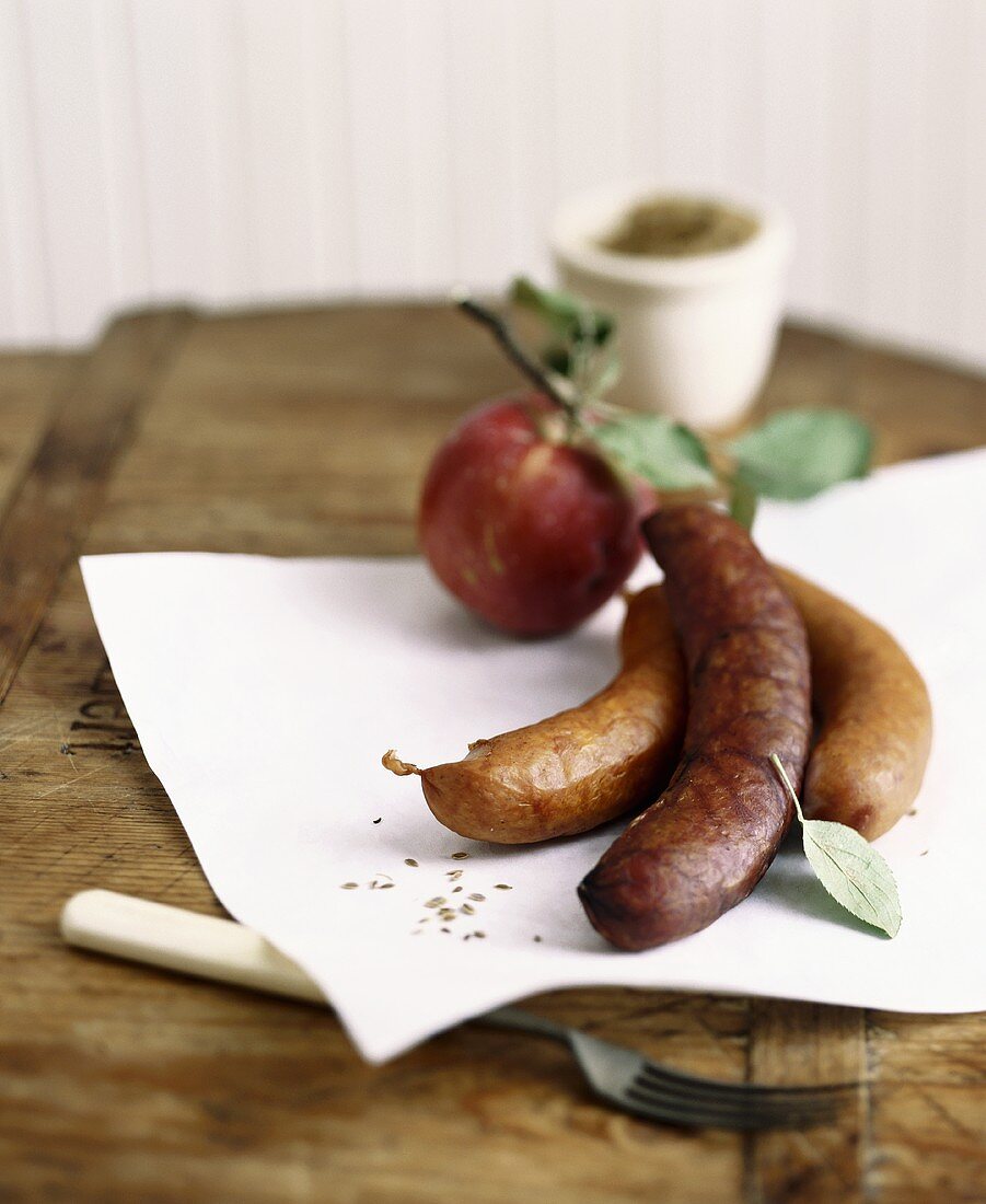 Herbstliches Stillleben mit Würstchen und Apfel