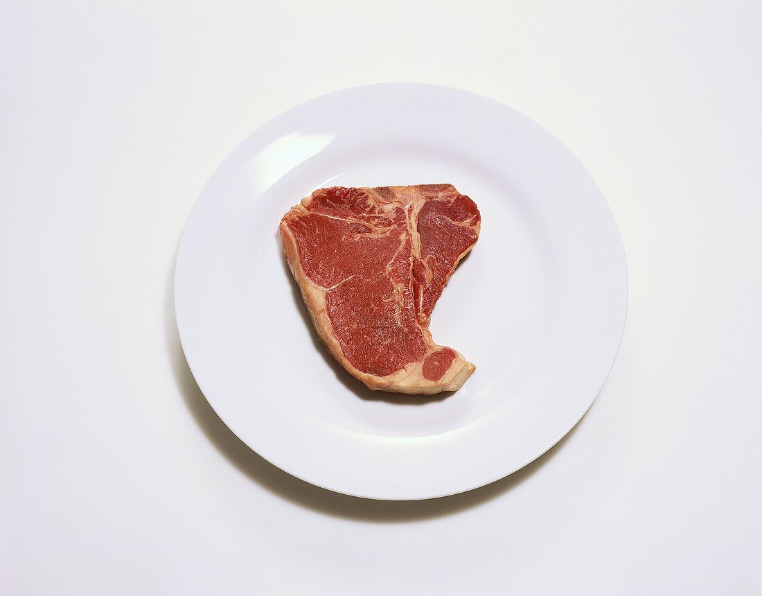 A Raw T-Bone Steak on a Plate