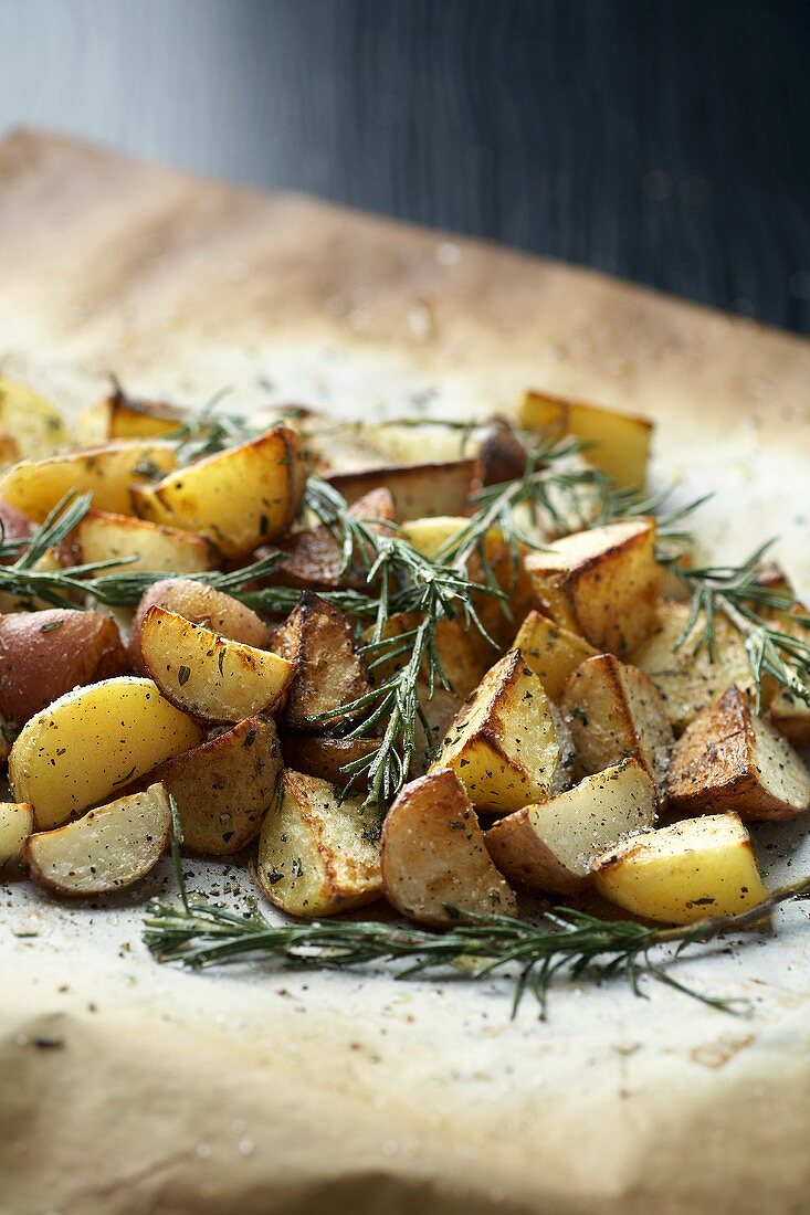 Roast potatoes with rosemary on baking parchment