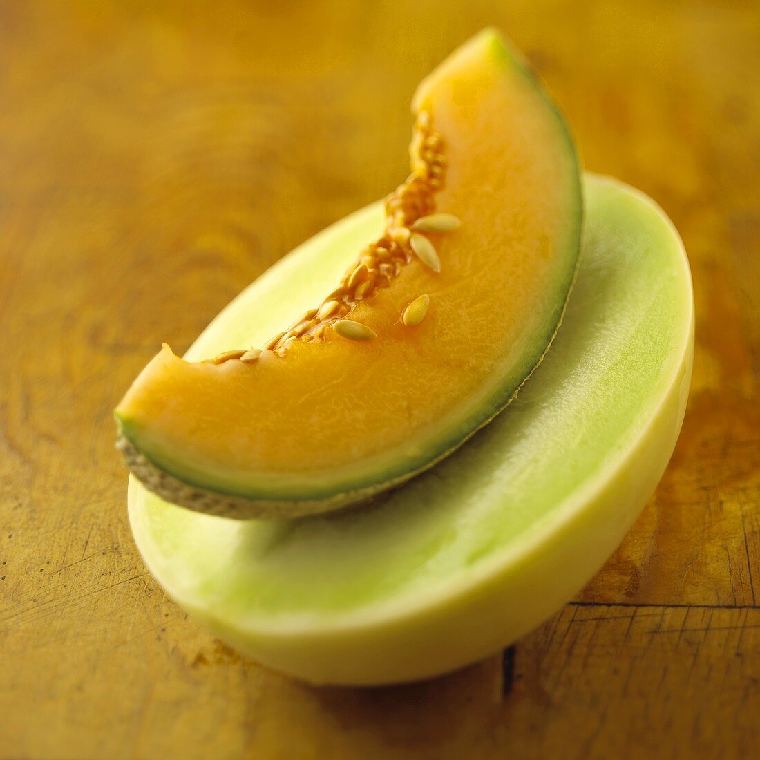 A Wedge of Cantaloupe on top of a Halved Honeydew Melon