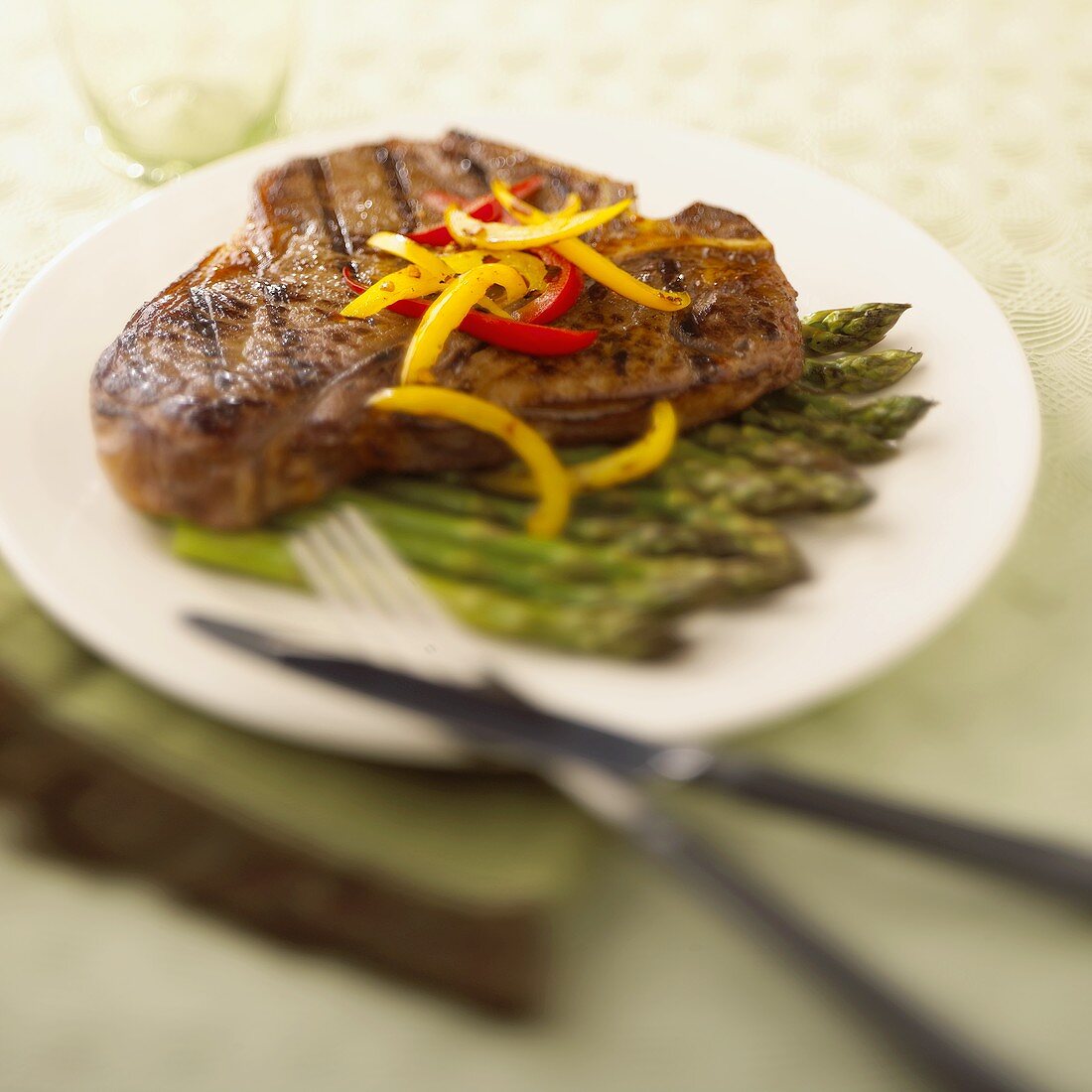 Gegrilltes T-Bone-Steak mit Paprika und grünem Spargel