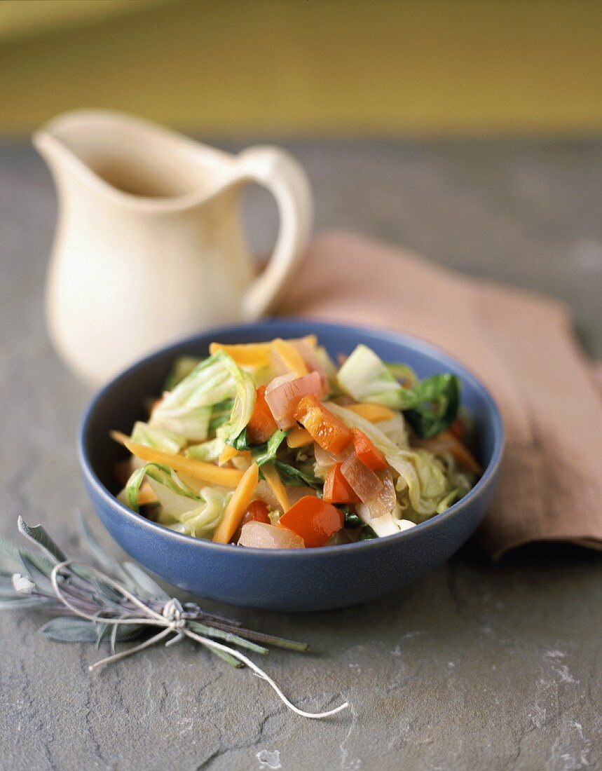 A Small Tossed Salad with a Pitcher of Dressing and Fresh Sage Leaves