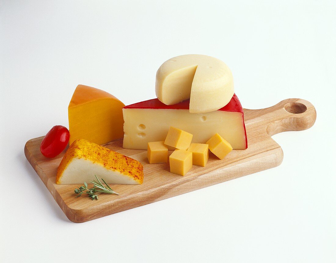 Assorted cheeses on wooden board