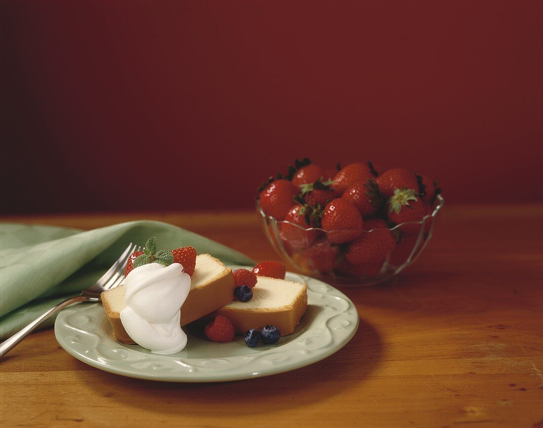 Zwei Stück Kuchen mit frischen Beeren und Sahne