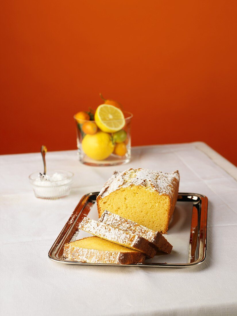 A Loaf of Lemon Cake, Partially Sliced, on a Silver Tray