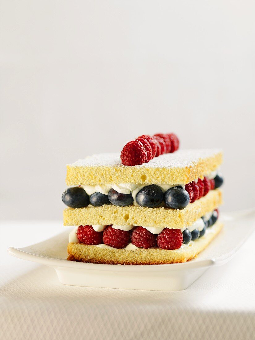 White Cake Layered with Cream, Raspberries and Blueberries