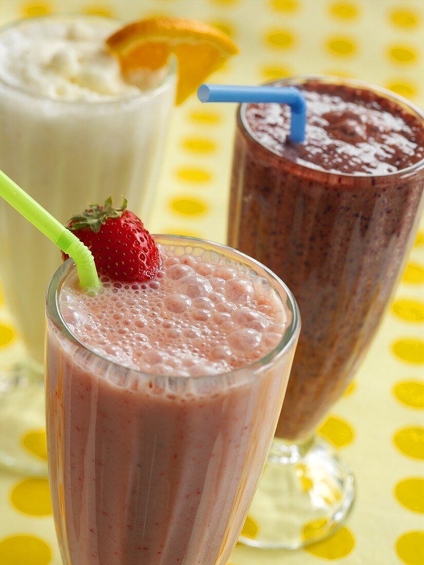 Drei Smoothies (Erdbeere, Himbeere und Zitrusfrucht)