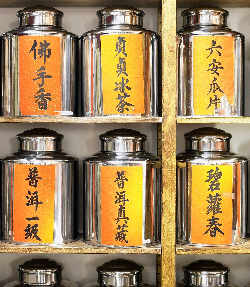 Several Chinese tea caddies on shelves
