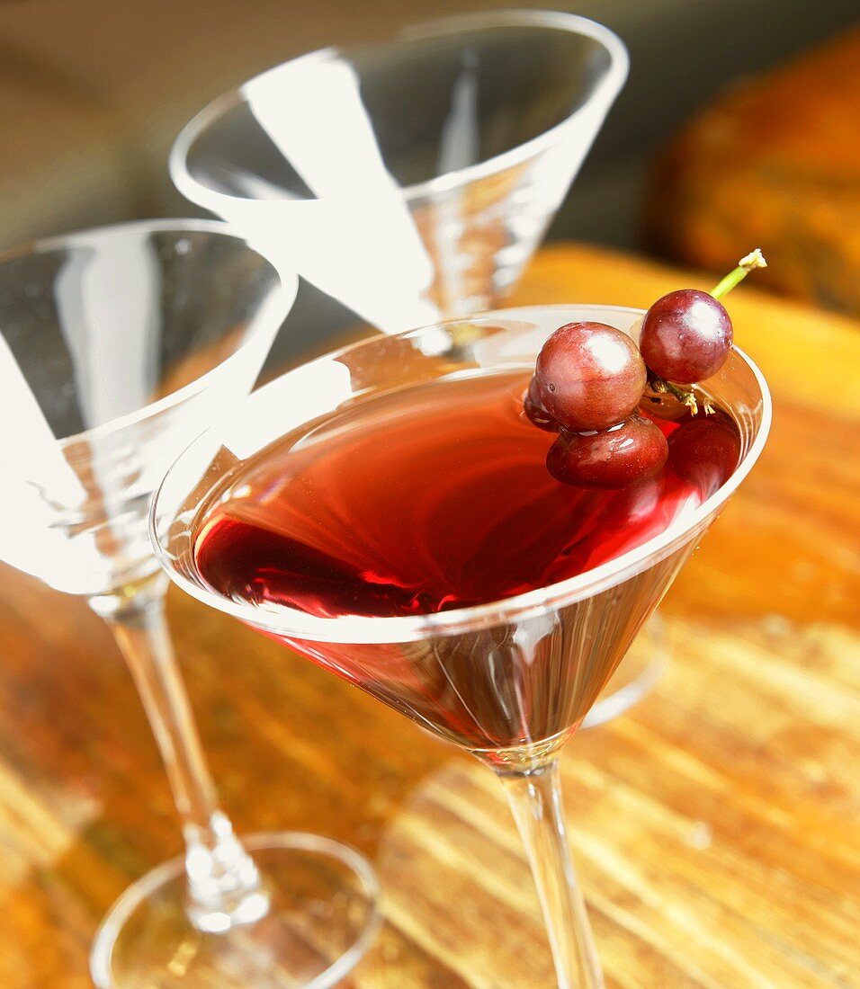 Grape Martini with Red Grape Garnish; Two Empty Martini Glasses