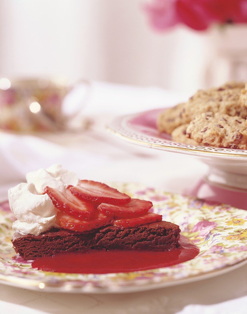 Chocolate cake with strawberry sauce and cream