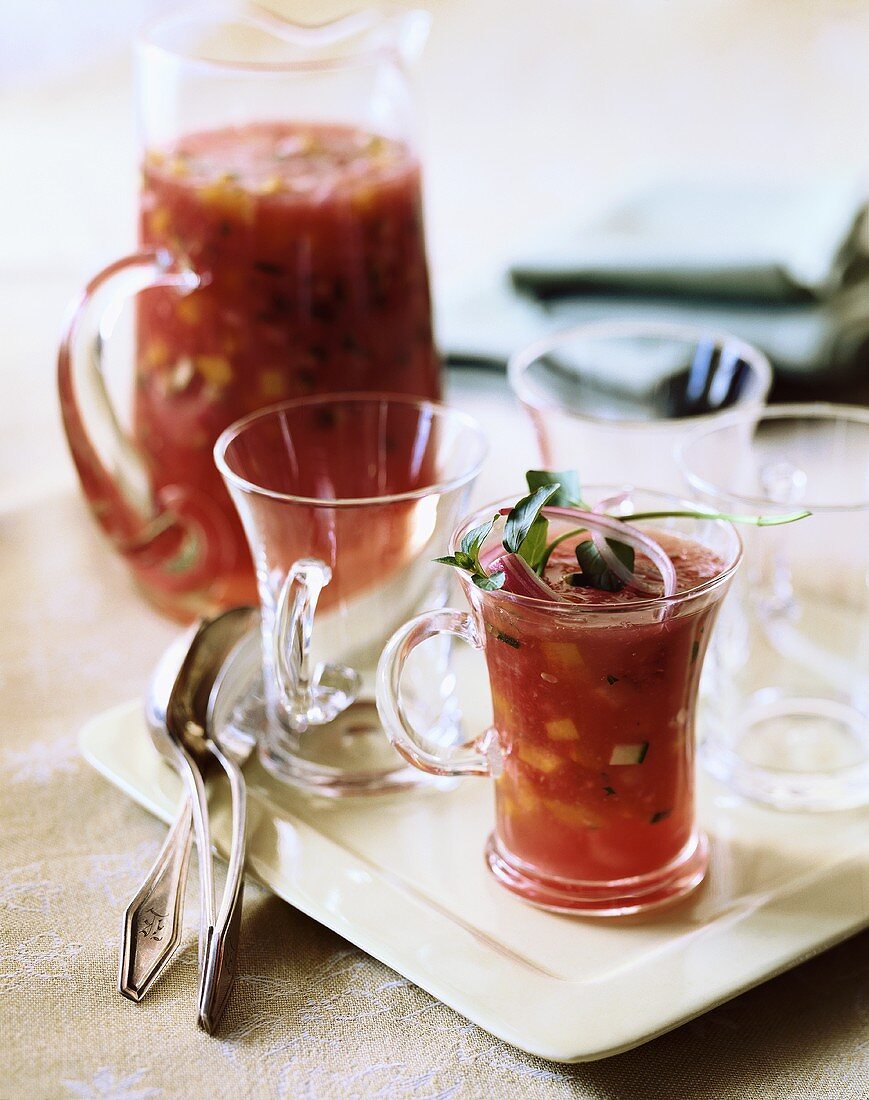 Gazpacho Served in Tall Glass Mugs Garnished with Red Onion; Pitcher of Gazpacho