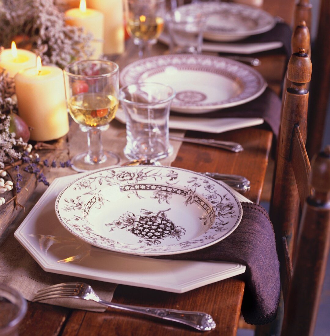 Holiday Table Setting with Black and White Plates, Candles and Glasses