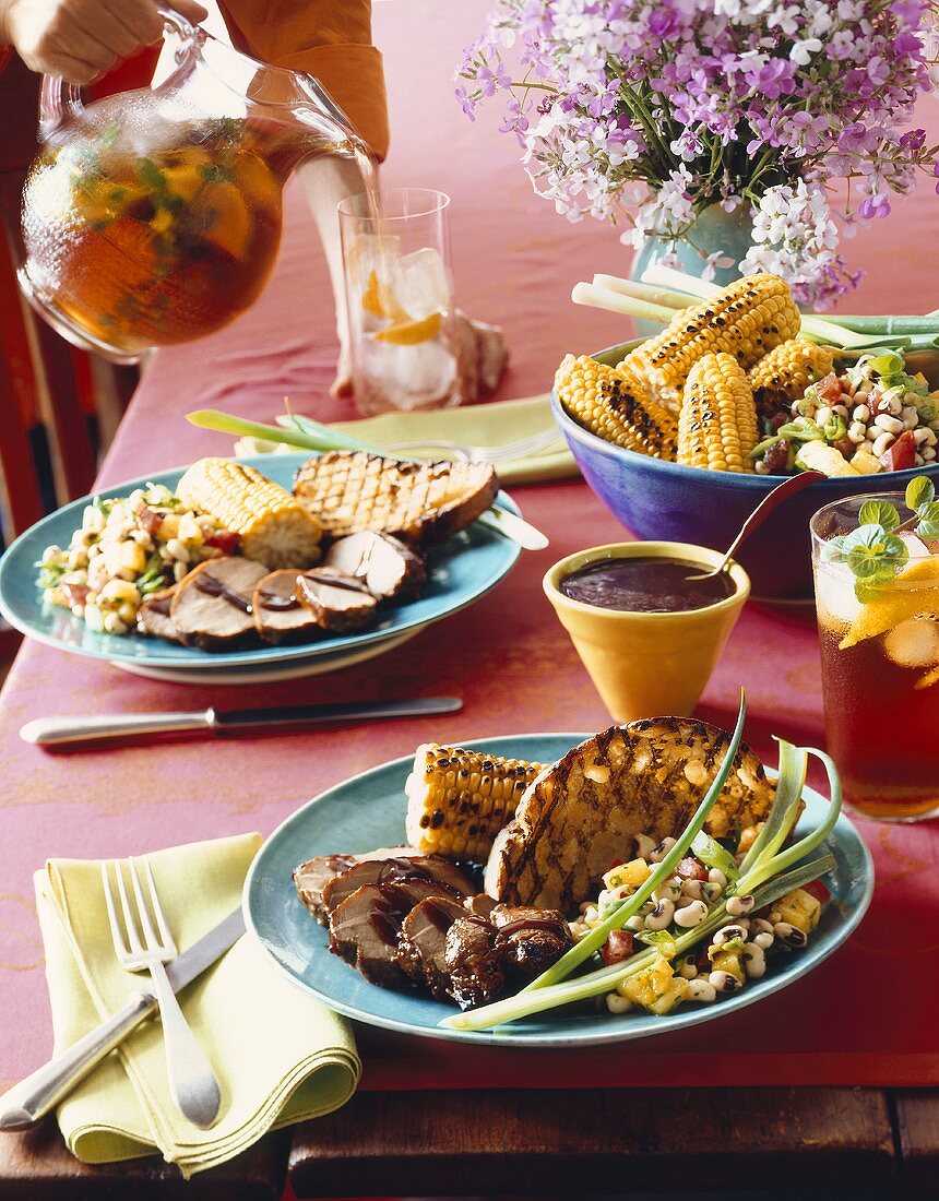 Schweinefleisch mit gegrillten Maiskolben, Brot & Bohnensalat