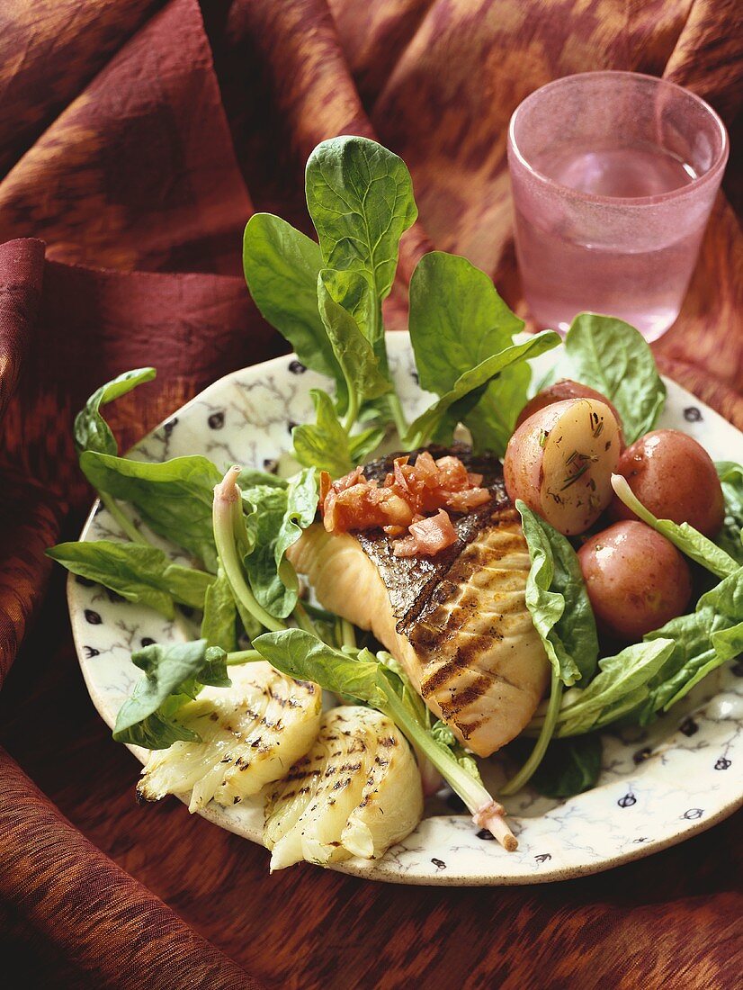 Gegrillter Lachs mit Zwiebeln und roten Kartoffeln auf Salat