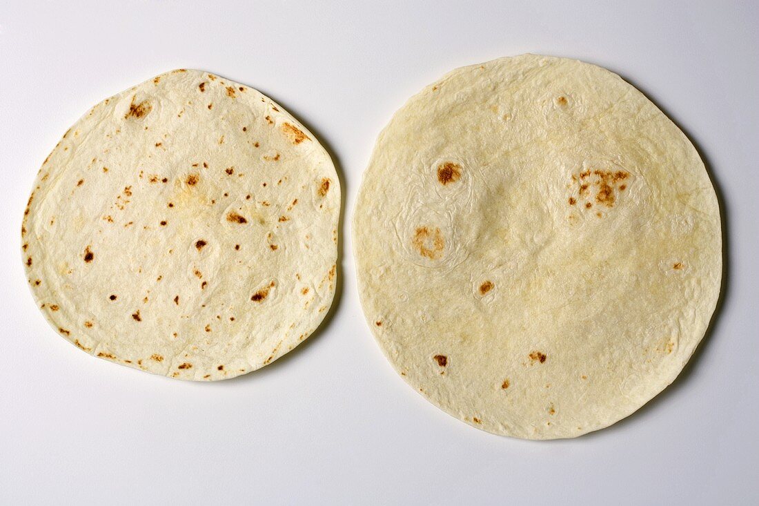 Two flour tortillas on white background