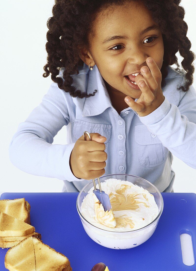 Girl stirring caramel cream into cream