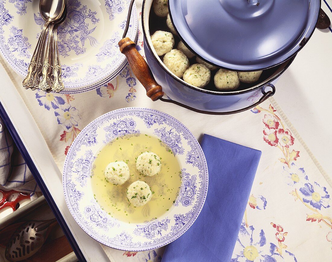 Overhead of Bowl of Matzo Ball Soup and Matzo Ball Soup in Pot; On Kitchen Counter