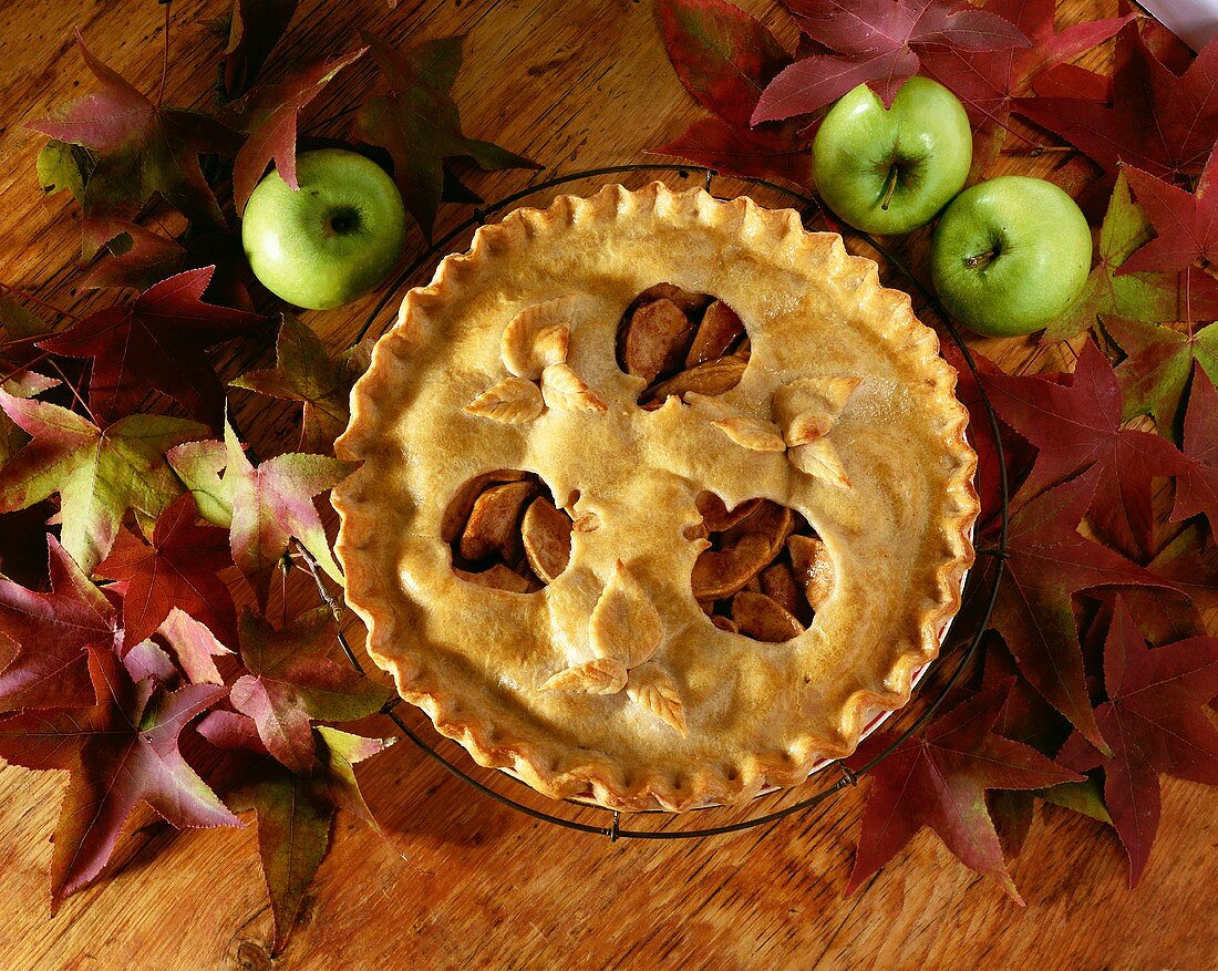 Overhead of Apple Pie with Apple Shaped Cut-Outs from Top Crust; Autumn Leaves and Apples