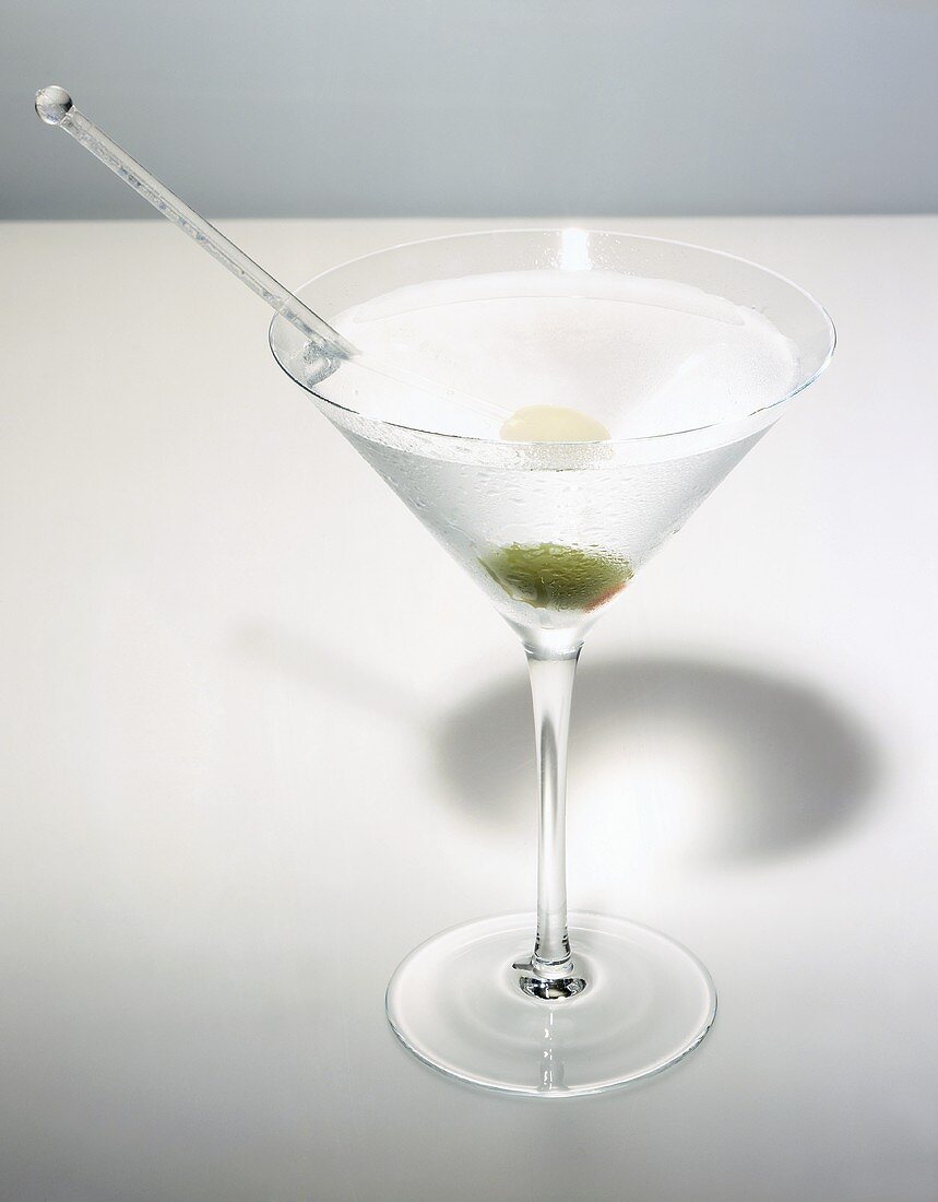 Martini with olive in glass with condensation