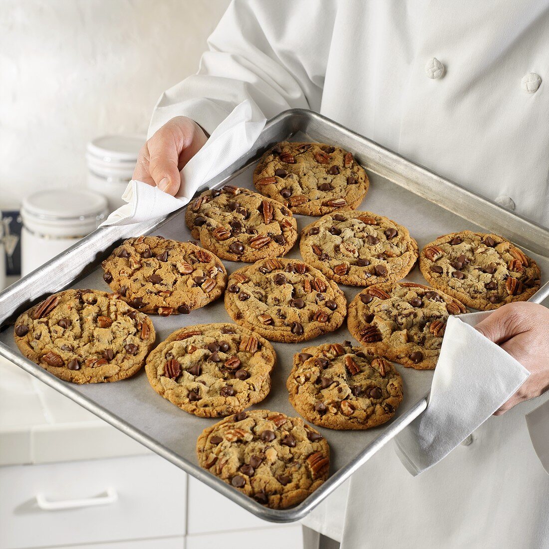Bäcker hält Backblech mit frisch gebackenen Cookies