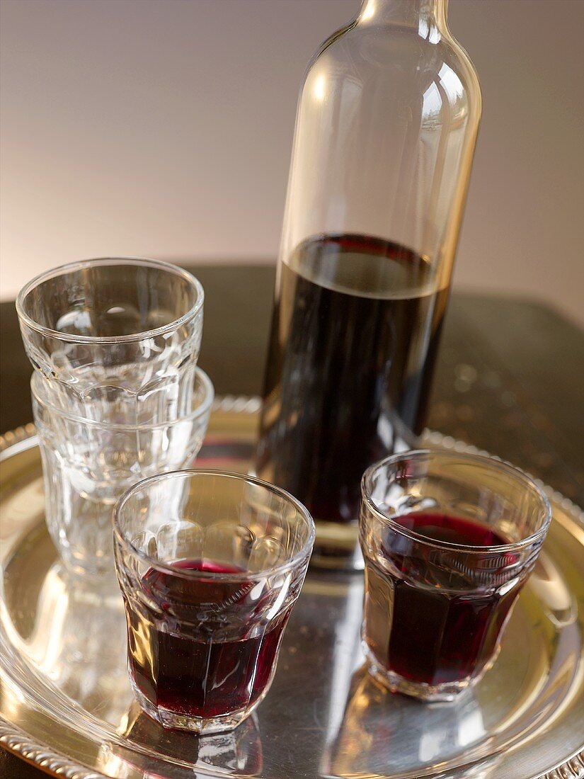 Rotwein in Gläsern und Flasche auf Silbertablett