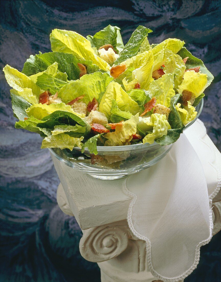 Caesar Salad in Large Glass Bowl on White Pillar